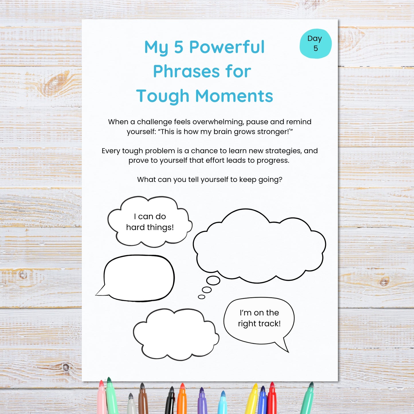 Sheet with 'My 5 Powerful Phrases for Tough Moments' on a wooden surface with markers.